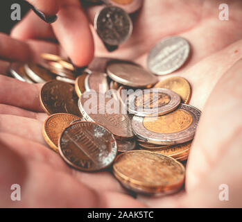 Femme tenant des pièces avec ses paumes. Banque D'Images