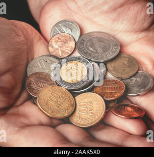 Femme tenant des pièces avec ses paumes. Banque D'Images