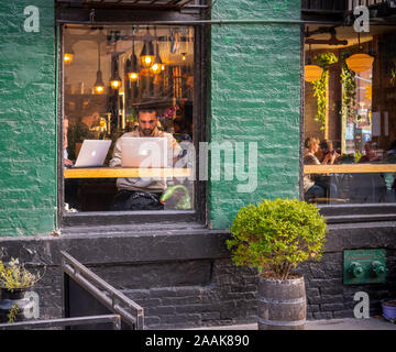 Les clients travailler et profiter de la connexion Wi-Fi gratuite dans un café-restaurant dans le Meatpacking District à New York, le vendredi 15 novembre, 2019. Le wi-fi et les tables communes encouragent l'utilisation de la cafétéria comme un espace de co-working. (© Richard B. Levine) Banque D'Images