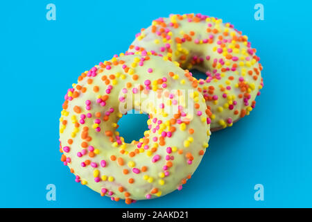 Les beignes glacés sur fond bleu. Avec un trou rond donut. Drôle de concept de l'humeur. La conception de l'alimentation moderne. Banque D'Images