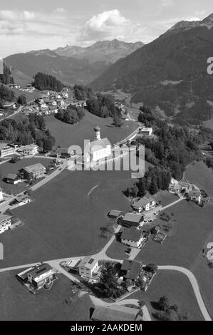 Autriche : le Barholomäus Airshot d'église au-dessus de Schruns tandis que le parapente dans la vallée du Montafon, Vorarlberg, Banque D'Images