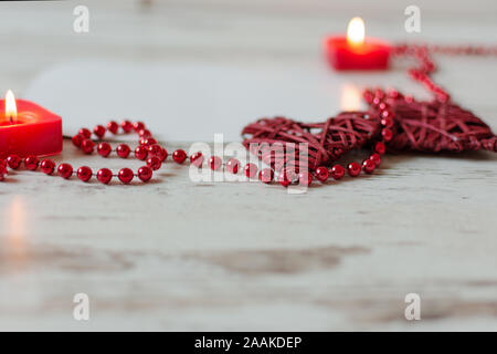 Coeurs avec perle rouge chaîne et bougies sur fond de bois. St Valentines Day ou carte de mariage concept avec copie espace . Banque D'Images