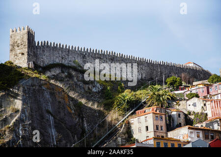 Porto, Portugal's 14e siècle domine la ville médiévale, ses collines environnantes de granit et vieilles maisons, comme vu de la rivière Douro. Banque D'Images