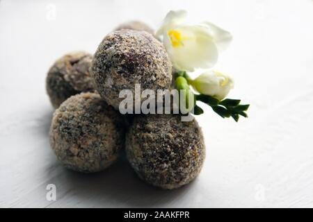 Rhum truffes au chocolat maison saine avec fleur blanche sur fond blanc. Bonbons savoureux. Banque D'Images