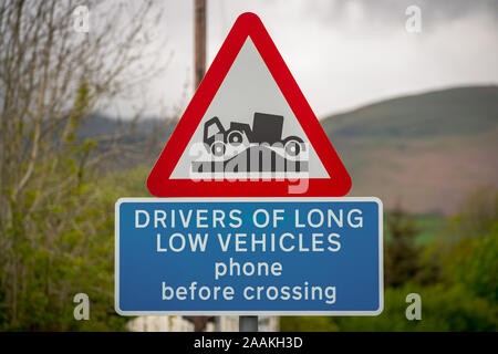 Inscription : Les conducteurs de véhicules à faible phone avant de traverser, avec l'arrière-plan flou. Vu dans Green Road, près de Strands, Cumbria, England, UK Banque D'Images