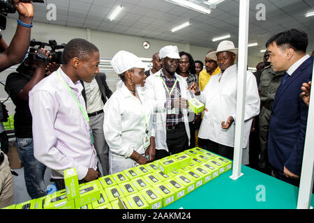(191122) -- MUKONO (Ouganda), du 22 novembre 2019 (Xinhua) -- Le Président ougandais Yoweri Museveni (2e R, à l'avant) se penche sur les produits finis à l'usine de téléphone de l'Engo Holdings Group Limited à Namanve Industrial Park à Mukono, Ouganda, le 22 novembre, 2019. Société d'électronique chinois, les ONGE Holdings Group Limited, le vendredi a ouvert une usine de 5 millions de dollars américains en Ouganda, qui fabriquera des téléphones cellulaires et les ordinateurs portables. (Photo par Hajarah Nalwadda/Xinhua) Banque D'Images