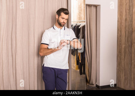 Homme adulte attendant femme dans les cabines d'essayage Banque D'Images