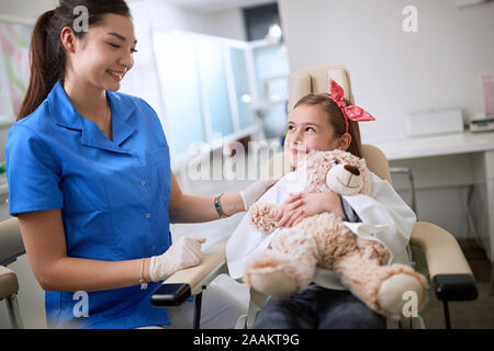 Les enfants dans une clinique dentaire. Peu smiling girl visiter dentiste . Banque D'Images