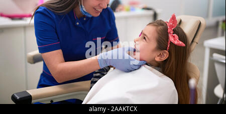 L'examen de son patient dentiste fille en Bureau du dentiste Banque D'Images