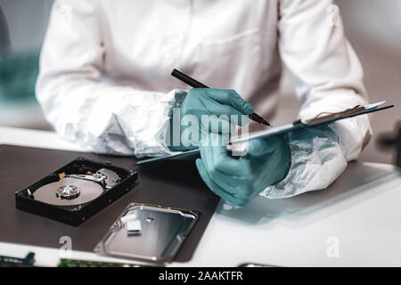 Technicien police scientifique l'examen de disque dur de l'ordinateur. Banque D'Images