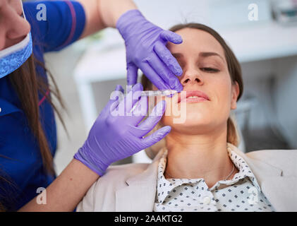 Young Woman receiving injection cosmétique sur ses lèvres.intervention cosmétique avec seringue Banque D'Images