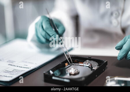 La criminalistique numérique. Analyste judiciaire Police Examen de disque dur de l'ordinateur. Banque D'Images