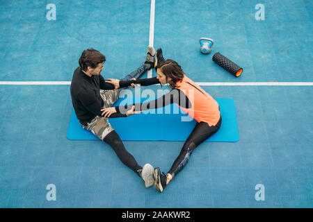 Fit young woman doing stretching après l'entraînement avec entraîneur personnel de conditionnement physique. Banque D'Images