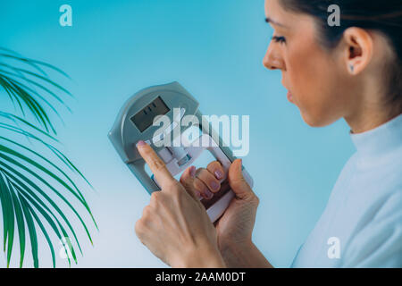 Woman using digital poignée dynamomètre. Banque D'Images