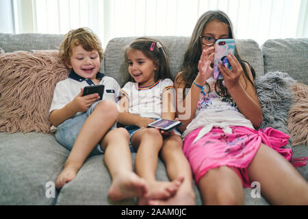 Bénéficiant d'amis des jeux d'ordinateur sur canapé Banque D'Images