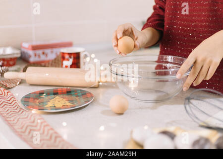 Close-up of woman breaking oeuf dans un bol Banque D'Images