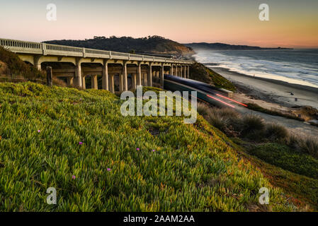 Locomotive diesel de voyageurs Amtrak circulant le long des voies de chemin de fer côtière sous le pont, Torrey Pines State Park à l'arrière, La Jolla, Californie, USA Banque D'Images