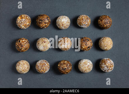 Des boules d'énergie avec les abricots secs, les raisins secs, les dattes, les pruneaux, noix, amandes et noix de coco. Une saine. Mise à plat, vue du dessus. Banque D'Images