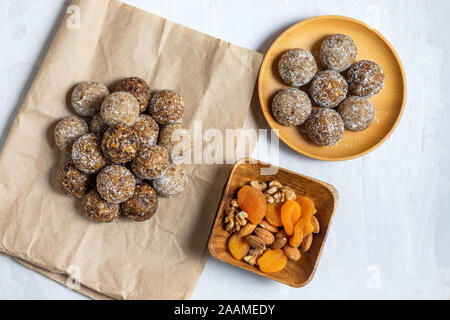 Des boules d'énergie avec les abricots secs, les raisins secs, les dattes, les pruneaux, noix, amandes et noix de coco. Une saine. Mise à plat, vue du dessus. Banque D'Images