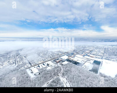 Une antenne / drone voir à plus d'une petite ville de l'Illinois après une tempête de neige avec les nuages à partir d'effacer et de la ville couverts. Banque D'Images