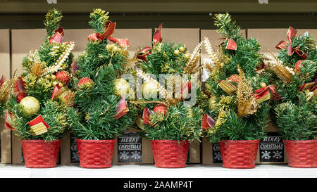 Arbres de Noël artificiels avec des boules d'or. Joyeux Noël, cadeau de Noël décoré avec des boules et des arcs. Souvenirs du Nouvel An Banque D'Images