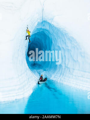 Ne sont pas le bateau ! - Un grimpeur sur glace qui part de canoë gonflable dans un lac glaciaire sur le Glacier Matanuska en Alaska. Banque D'Images