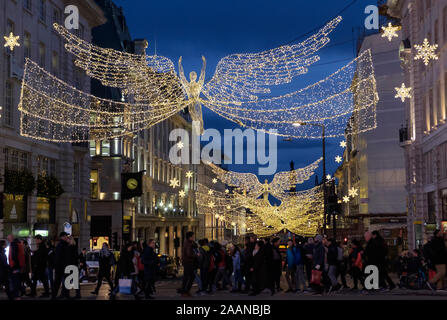 Lumières de Noël Angel Piccadilly Circus pendant leurs achats londoniens et touristes traverser la rue. Le centre de Londres, UK Banque D'Images