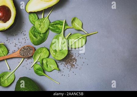 L'avocat, les épinards et les semences chia sur fond noir en gris, vue du dessus. Ingrédients pour faire des smoothie vert ou salade. Banque D'Images