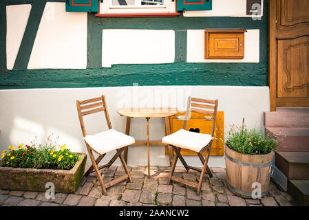 Table et chaises en bois confortables en face d'une maison typiquement allemande de style ancien. Banque D'Images