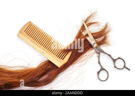 Ciseaux avec une mèche de cheveux et un peigne sur blanc fond isolé Banque D'Images