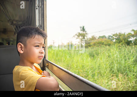 Portrait of asian boy sur la fenêtre d'arrière-plan de vue et les arbres. Banque D'Images