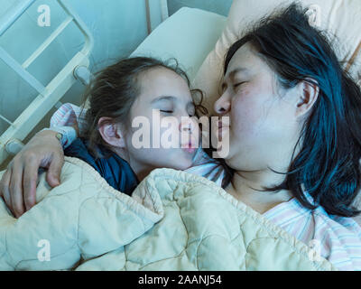 Mère et fille asiatique pose en hosital lit ensemble Banque D'Images