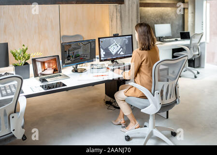 Jeune employé qui fait office de création d'intérieur, la modélisation 3D sur l'ordinateur lors de l'assise à la société d'architecture de bureau moderne Banque D'Images