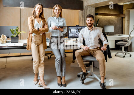 Portrait d'une équipe créative et confiante d'architectes ou designers debout ensemble dans le bureau moderne studio Banque D'Images