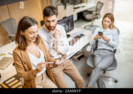 Avoir des collègues de travail créatif à l'aide de tablette numérique et un crayon à l'office moderne studio. Concept de la conception sur une tablette numérique Banque D'Images