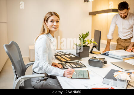 Portrait d'une femme belle de faire certains travaux de création à la grande table avec des collègues au bureau. Concept d'une entreprise d'architecture et de création Banque D'Images