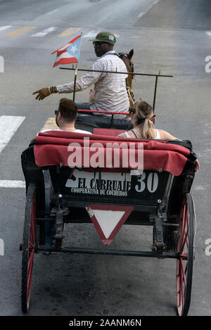 Une calèche touristique emmenant un couple de touristes en visite de la ville à la Havane, Cuba. Banque D'Images