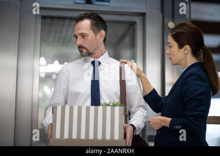 Office worker holding box tout en laissant l'office après le licenciement Banque D'Images