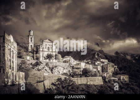 Image sépia de the storm clouds accroché sur la montagne au-dessus de l'ancien village de Montemaggiore en Balagne de Corsic Banque D'Images