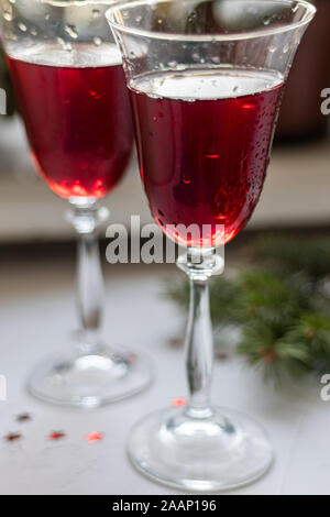 Vin rouge dans des verres transparents. Sur un fond clair. Arrière-plan flou derrière. Les branches d'arbre de Noël. Copier l'espace. Banque D'Images