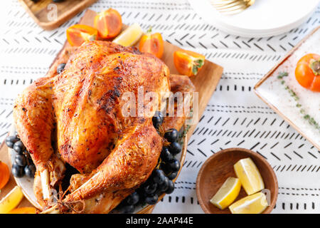 Rôti Entier sur une table avec la Turquie, plaqueminier du raisin bleu et citron pour la famille de Thanksgiving. Banque D'Images