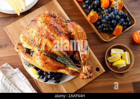 Rôti Entier sur une table avec la Turquie, plaqueminier du raisin bleu et citron pour la famille de Thanksgiving. Banque D'Images