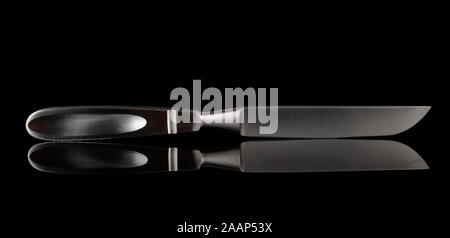 Liston amputation knife tourné sur surface noire avec reflet Banque D'Images