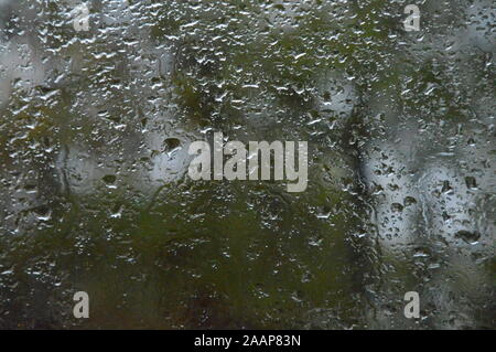 Gouttes de pluie sur la fenêtre avec l'arrière-plan des forêts Banque D'Images