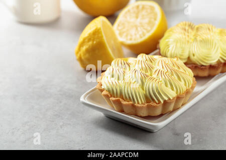 Tartelettes à la crème de citron sur une table de marbre blanc. Banque D'Images