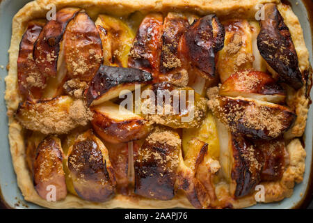 Une tarte à base de pâte brisée, le jus de citron, le sucre brun et les pommes qui avaient été laissés à l'extérieur d'une maison avec un verger et awa Banque D'Images