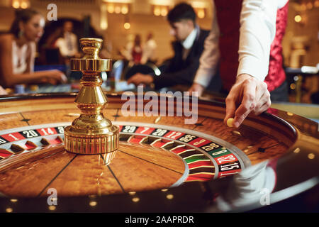 Main d'un casino avec une balle sur une roulette au cours d'une partie dans un casino. Banque D'Images