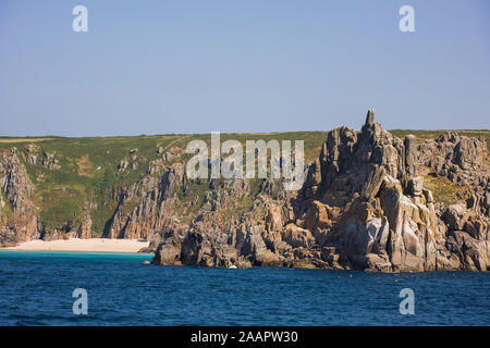 Teryn Dinas et plage de Porthcurno, West Penwith, Cornwall, UK à partir de la mer sur une calme journée d'été Banque D'Images