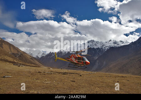 Hélicoptère rouge et jaune en venant d'atterrir à Kyanjin Gompa Banque D'Images