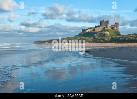 Château de Bamburgh haut perchées sur des rochers escarpés surplombant les dunes côtières, de la plage et de la mer du Nord. Northumberland, Angleterre Banque D'Images